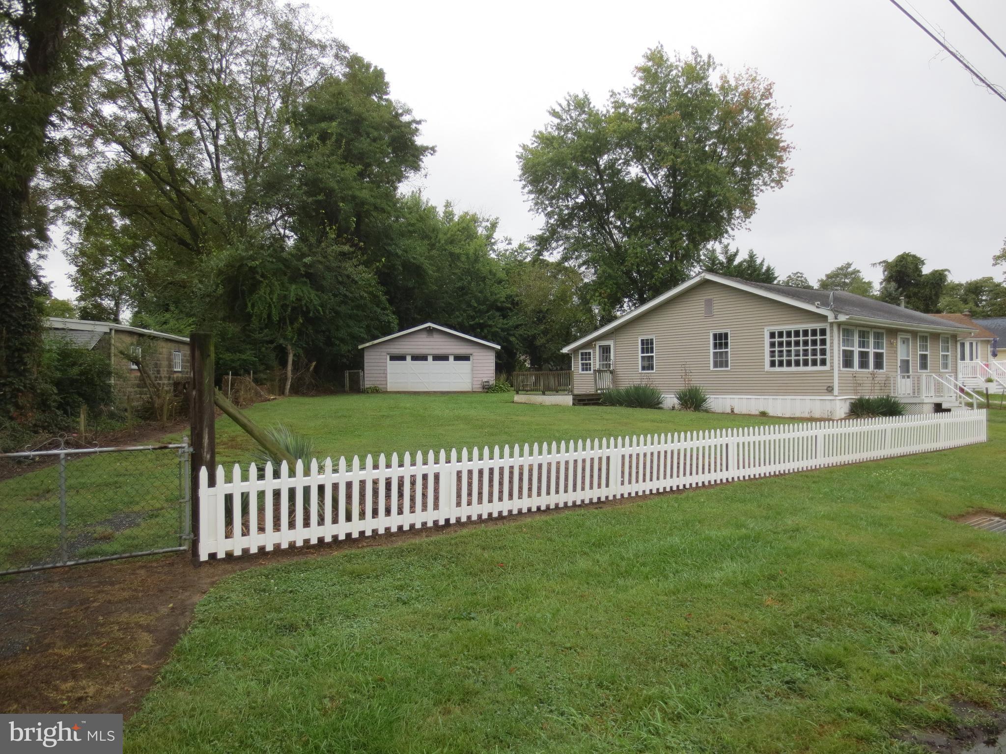 21 Hacks Point Road Earleville, MD 21919 - Photo 2 of 15 a view of a white house with a small yard and a garden