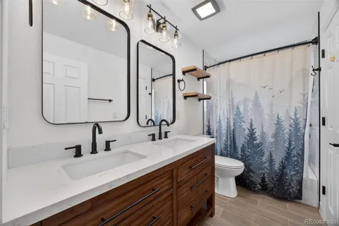 a bathroom with a double vanity sink mirror and shower