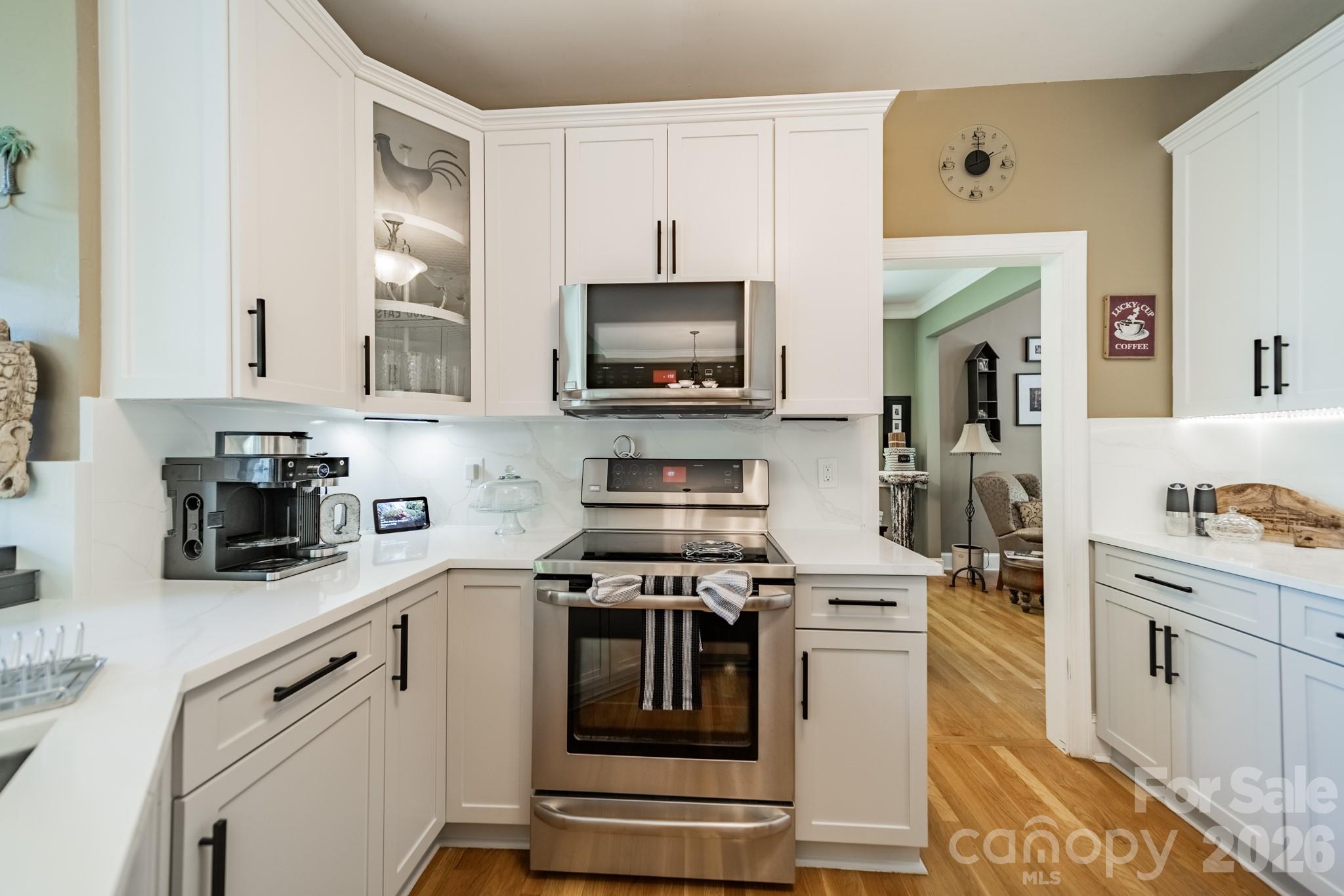 11043 Seven Coves Drive Tega Cay, SC 29708 - Photo 28 of 45 a kitchen with stainless steel appliances granite countertop grey cabinets a stove a sink and a microwave