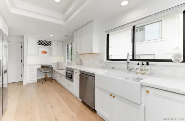 a white bed sitting in a bedroom next to a window