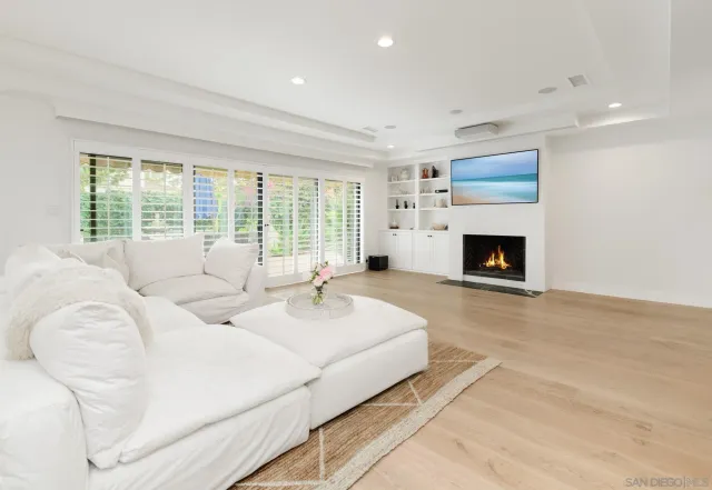 a living room with furniture large window and a fireplace