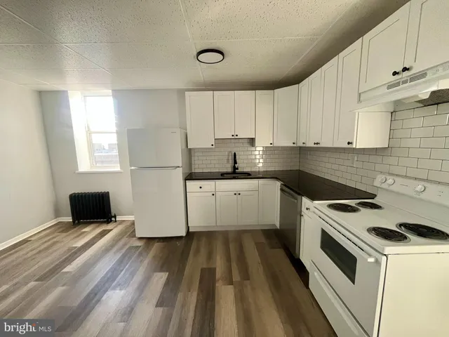 a white kitchen with sink and white stainless steel appliances