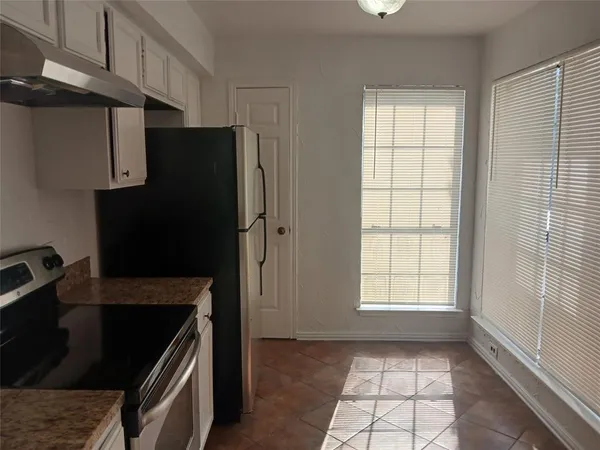 a kitchen with a refrigerator stove and cabinets
