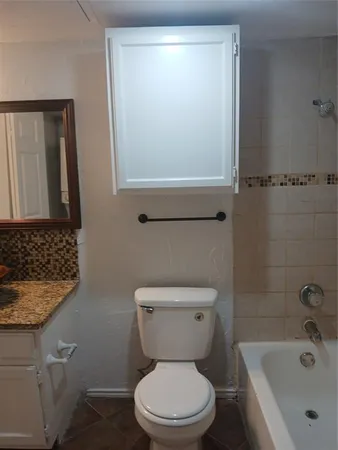 a white toilet sitting next to a bathroom sink