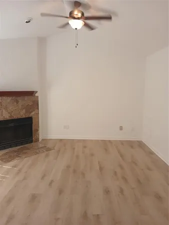 an empty room with a fireplace and fan