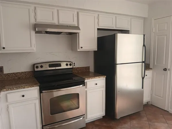 a kitchen with refrigerator a stove and cabinets