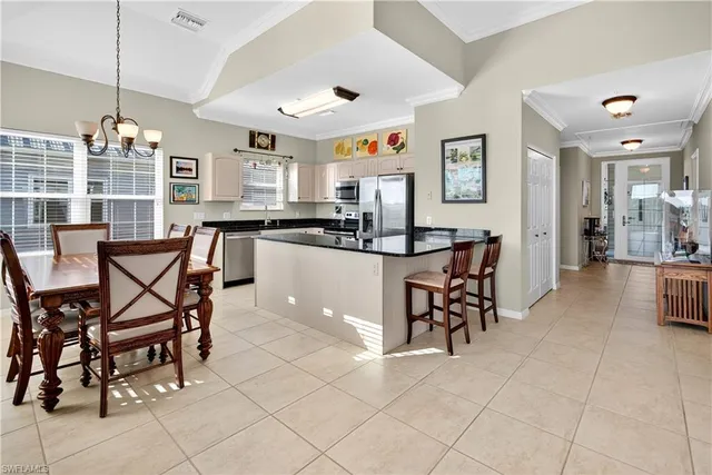 a kitchen with stainless steel appliances a dining table chairs and granite counter tops