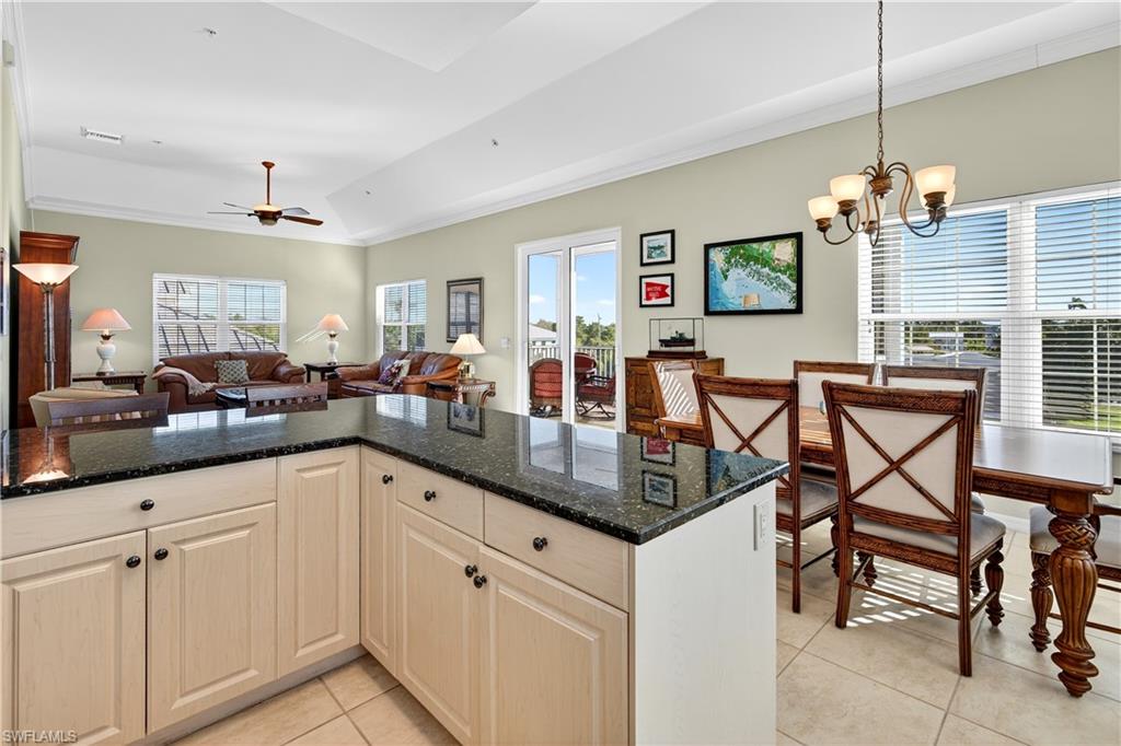 322 Angler Drive, Unit 502 Goodland, FL 34140 - Photo 38 of 38 Kitchen featuring dark stone countertops, open floor plan, ornamental molding, light tile patterned floors, and hanging light fixtures