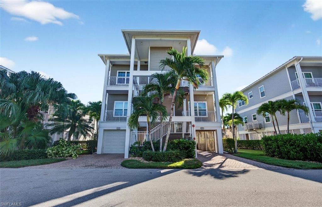 322 Angler Drive, Unit 502 Goodland, FL 34140 - Photo 3 of 38 Beach home with stairway, decorative driveway, a balcony, and an attached garage