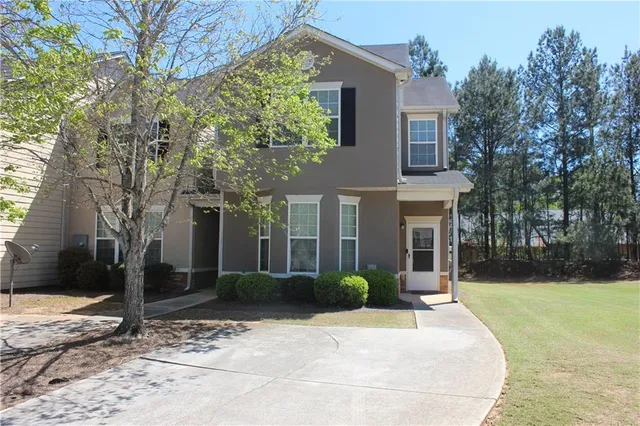 a front view of a house with a yard and potted plants