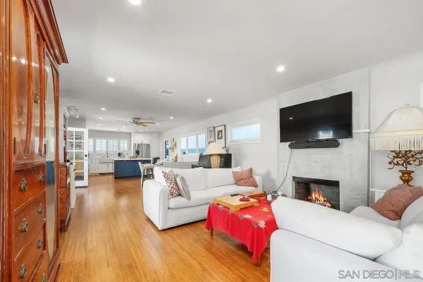 a living room with furniture fireplace and large windows