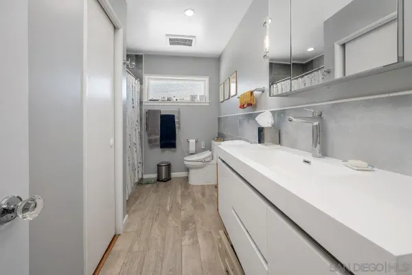a bathroom with a sink a toilet and shower