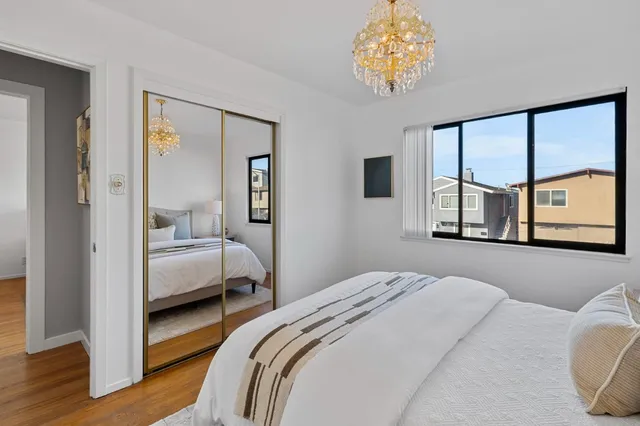 a bedroom with a bed and a large window with the outer view