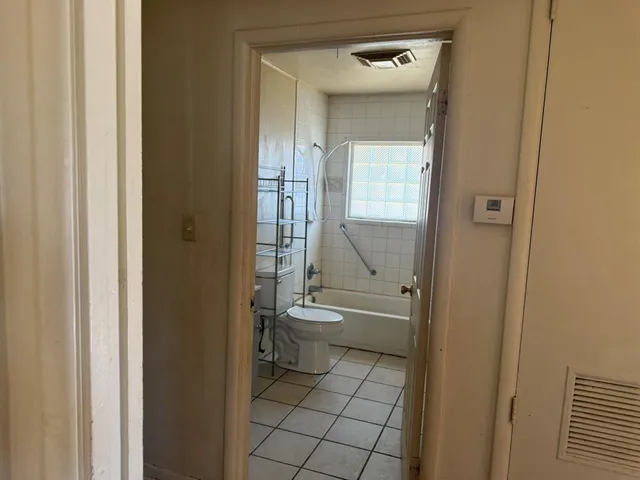 a bathroom with a granite countertop toilet a sink and a mirror