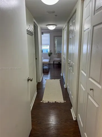 a view of a hallway with wooden floor windows and a livingroom