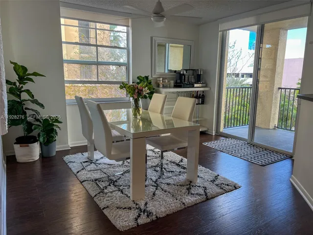 a view of a dining room with furniture a potted plant and wooden floor