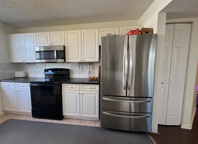 a kitchen with stainless steel appliances granite countertop a refrigerator and a stove top oven
