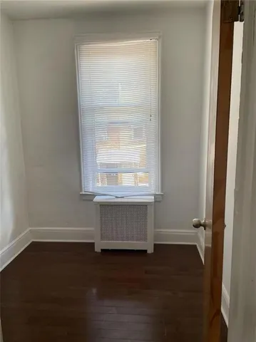an entryway with wooden floor and cabinet