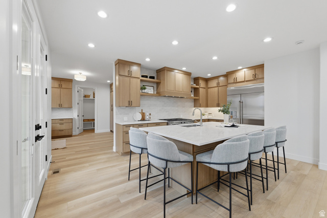702 Alpine Highway Alpine, UT 84004 - Photo 28 of 83 Expansive kitchen featuring light wood-finish cabinetry, a large center island with seating, stainless steel appliances, white countertops, and light wood-finish flooring
