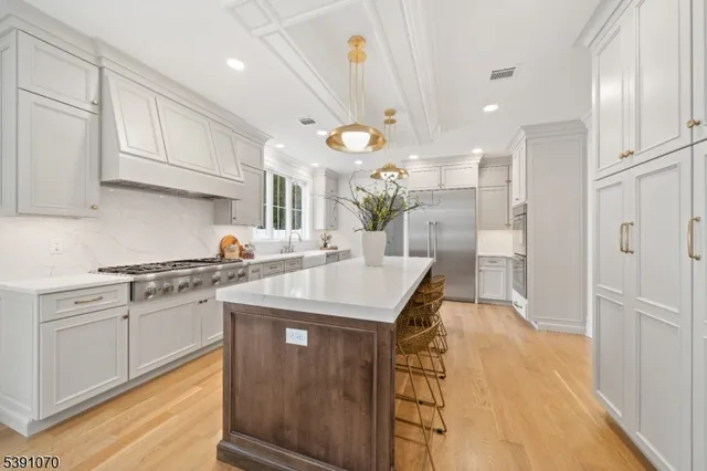 a kitchen with stainless steel appliances granite countertop a sink a stove and a refrigerator