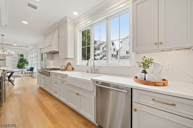 a kitchen with white cabinets and sink