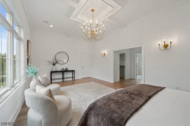 a bedroom with bed and a chandelier