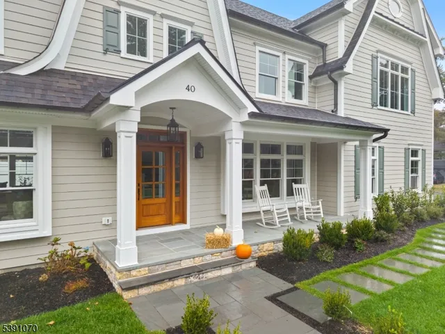 a front view of a house with outdoor seating and a yard