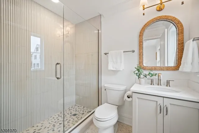 a bathroom with a granite countertop sink a toilet and a mirror