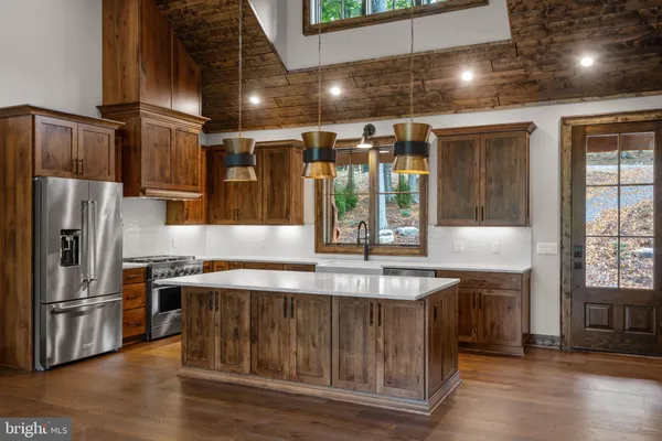 a kitchen with stainless steel appliances granite countertop a sink and a refrigerator