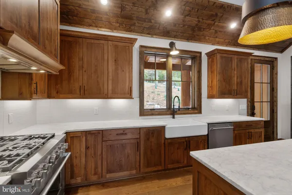 a kitchen with granite countertop a sink a stove and wooden cabinets