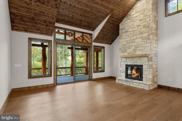 a view of an empty room with a fireplace and a window