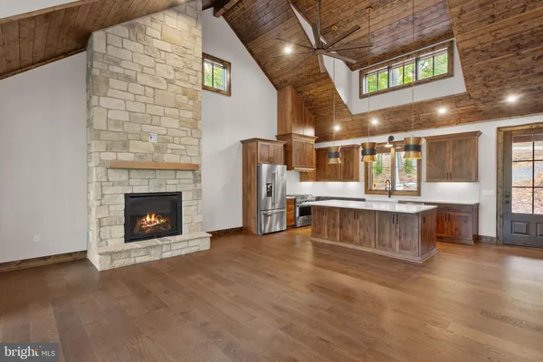 a living room with stainless steel appliances kitchen island furniture and a fireplace