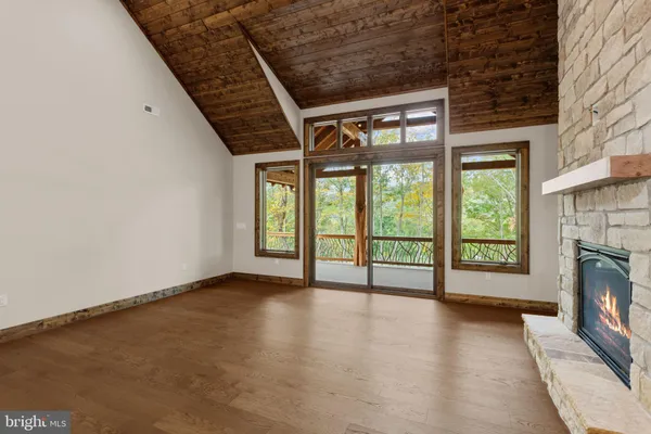 a view of an empty room with a fireplace and a window