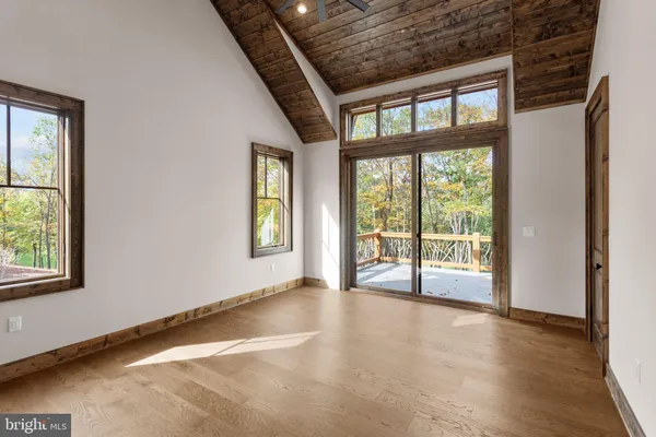 an empty room with wooden floor and a fireplace
