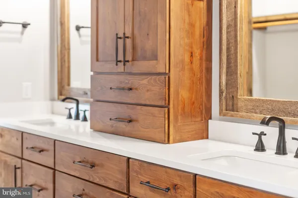 a view of an empty room with wooden floor and a fireplace