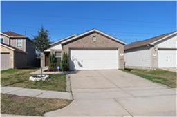 This is a single-story brick home with a two-car garage. It features a clean driveway, a small front yard with minimal landscaping, and is set in a neighborhood with similar style houses.