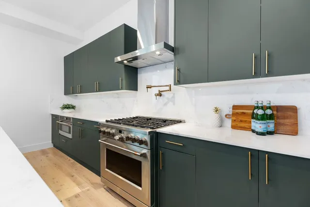 a outdoor kitchen with stainless steel appliances kitchen island a table chairs microwave and sink