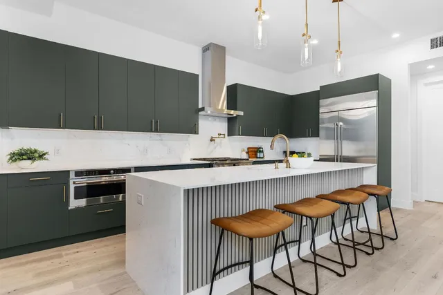 a kitchen with stainless steel appliances granite countertop a stove and a sink