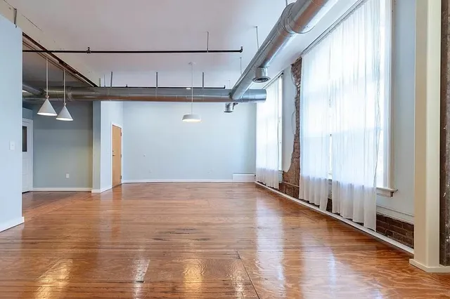 a view of empty room with wooden floor
