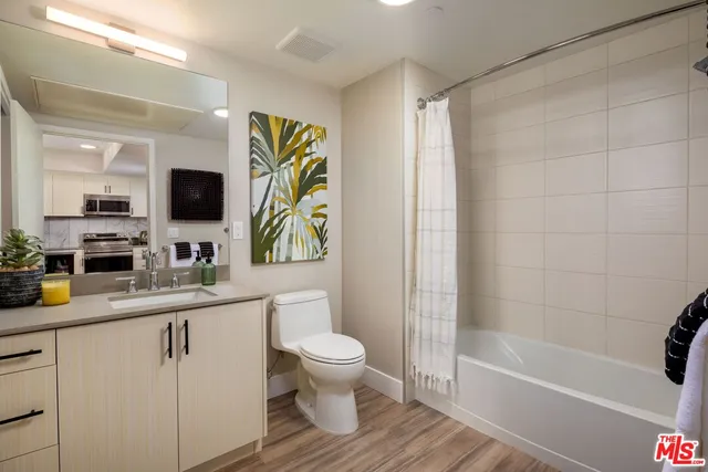 a bathroom with a sink a toilet and a large mirror