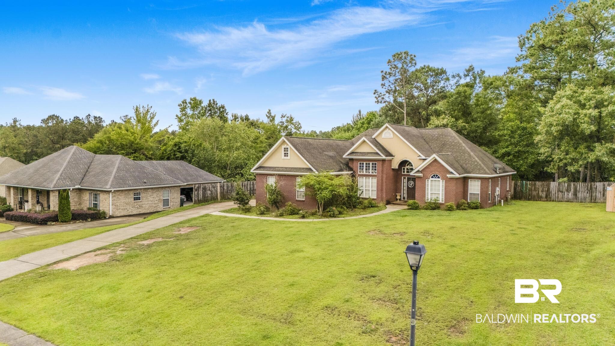 35814 Delvan Lane Bay Minette, AL 36507 - Photo 41 of 53 Brick exterior residence with a prominent arched entry, multiple gabled rooflines, and a well-maintained front lawn