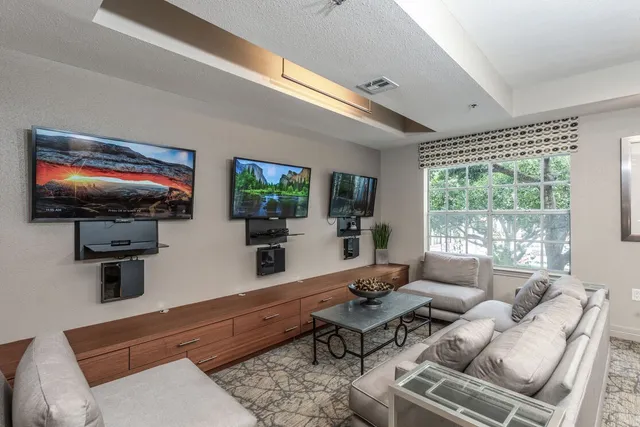 a living room with furniture flat screen tv and a large window