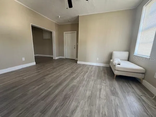 a view of a livingroom with wooden floor and furniture