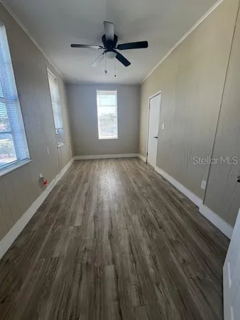 a view of a livingroom with wooden floor and a ceiling fan