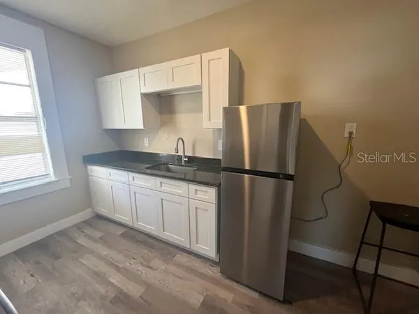 a kitchen with a refrigerator and a sink