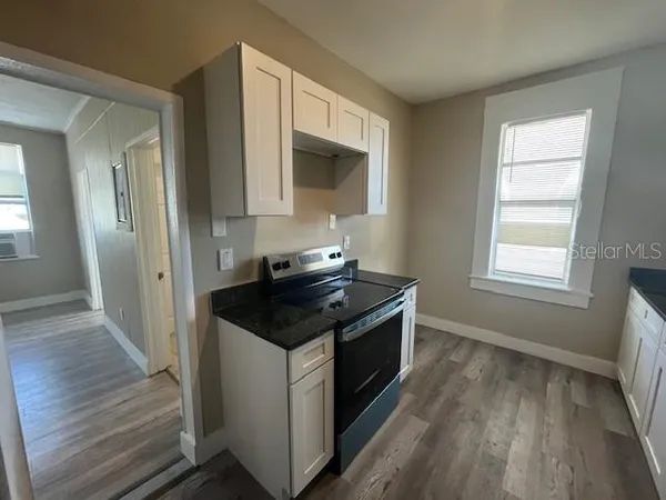 a kitchen with granite countertop a stove and a sink