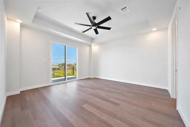 a view of a livingroom with a ceiling fan wooden floor and a ceiling fan