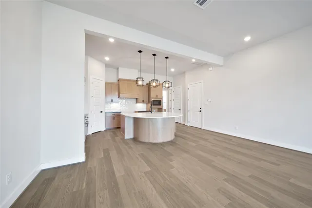 a large kitchen with a lot of cabinets and wooden floor