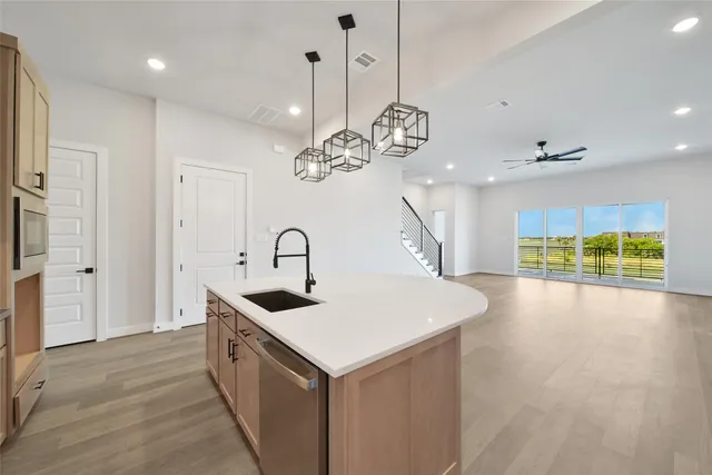 a kitchen that has a lot of cabinets and a wooden floor