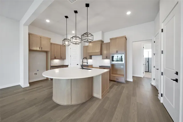 a large kitchen with stainless steel appliances a large center island attached withe living room